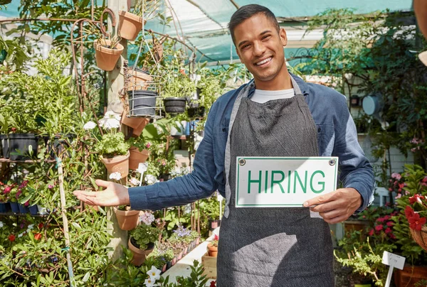 Plants, garden or manager with a hiring sign at a small business with flowers, nature or growth sustainability. Portrait, job offer or happy business owner with an onboarding banner in gardening shop.