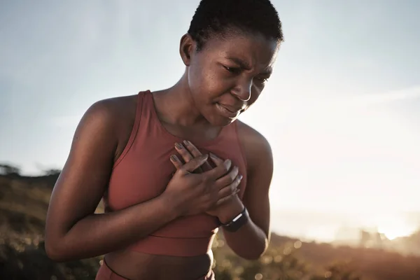Black woman, runner and heart attack pain in nature while running outdoors. Sports, cardiovascular emergency and female athlete with chest pain, stroke or cardiac arrest after intense cardio workout