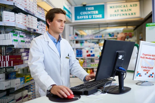 Weve got your medical history all saved for easier service. a young pharmacist working on a computer in a chemist