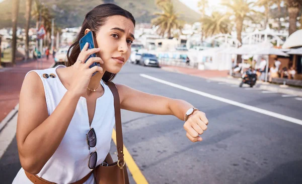 Phone call, time and woman waiting for taxi in city while talking, speaking or chatting. Travel destination, watch and late female on 5g mobile smartphone in discussion with contact outdoors in town