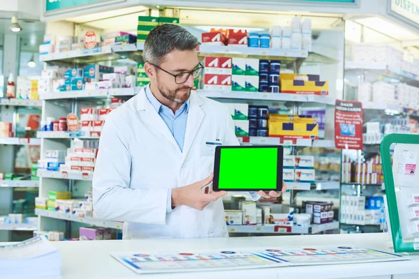 Pharmacists are constantly in communication with their patients. a pharmacist holding up a tablet with a chromakey screen
