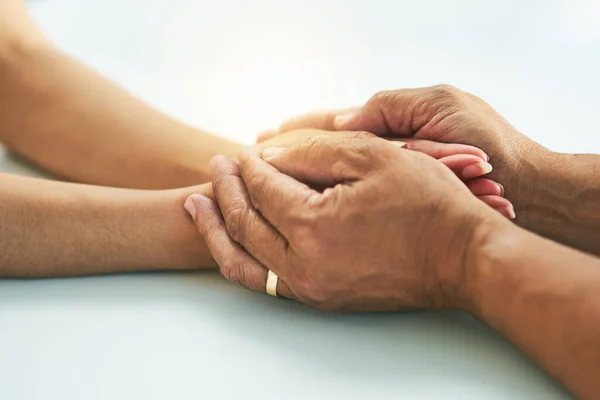 There will always be a helping hand. Closeup of a doctor holding a patients hands in comfort inside of a hospital during the day