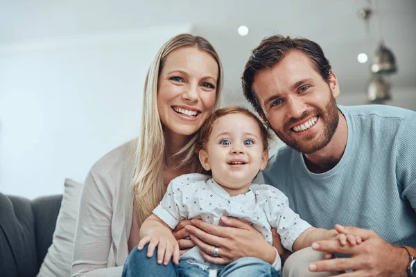 Family, happy portrait and relax with baby on sofa in living room for love, support and quality time bonding. Parents smile, holding kid and happiness together for trust on couch in family home.