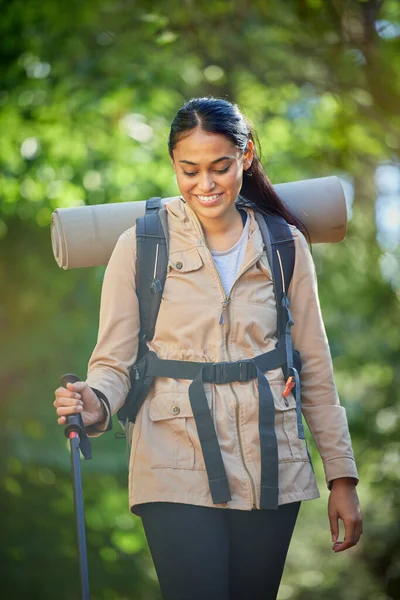Hiking, travel and woman with trekking pole for stability or mobility outdoors. Freedom, adventure or happy female hiker from India exercise or training with walking stick for tough terrain in nature.
