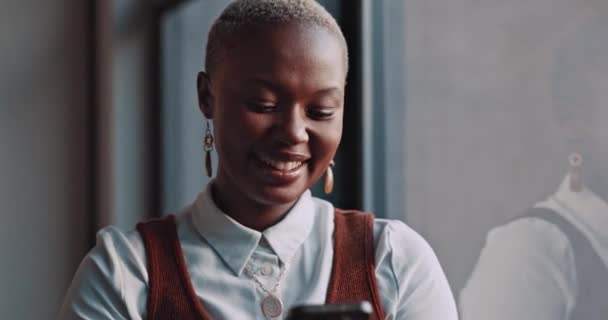 オフィスの窓のそばに立ちながら 電話で黒人女性の幸せ 笑顔と顔 幸福とソーシャルメディアや職場で休憩中のインターネット上のアフリカの女性従業員ネットワーク — ストック動画