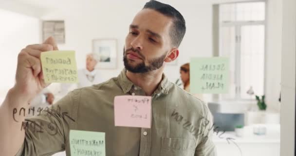 思考和贴纸与一个商人写在玻璃板上在他的办公室董事会 创新和远见 由男性员工工作或集思广益 — 图库视频影像