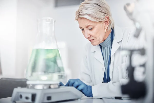 Senior scientist woman, laboratory and beaker for study, analysis and focus for job in pharma industry. Science, lab and working with pharmaceutical research for vision, future or analytics in Sweden.