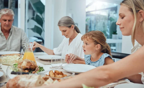 Family, holding hands or praying to God for food with mother, grandparents or girl child ready for dinner meal. Christmas, worship or spiritual Christian people with faith or prayer love eating lunch.