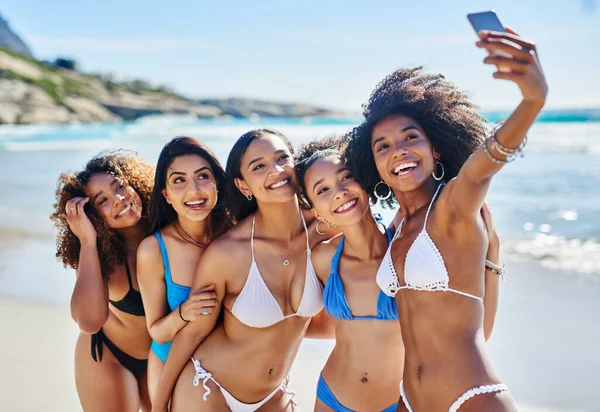 If youre not at the beach, youre not having fun. a group of happy young women taking selfies together at the beach