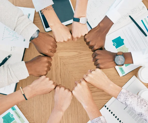 Diversity, fist hands and teamwork with documents on table for marketing business meeting, creative collaboration and goals support motivation. Team, circle hand and planning strategy or logistics.