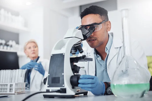 Science, microscope and innovation with a doctor man in a laboratory for research or medical development. DNA, healthcare and medicine with a male scientist working in a lab for sample analysis.