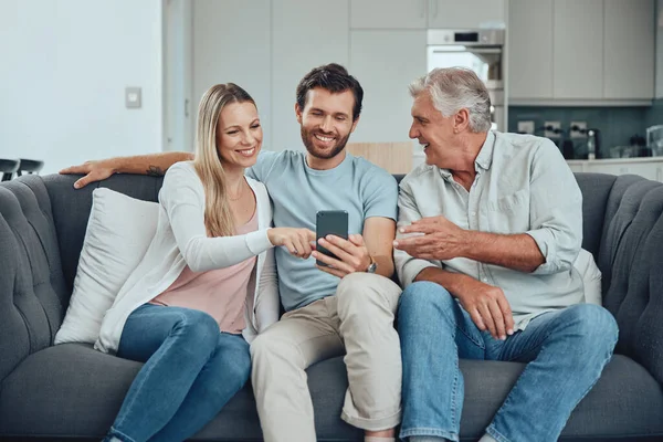 Relax, search and phone with family on sofa for share internet, social media or online news. Care, retirement and help grandfather with man and woman in living room for technology, digital or contact.
