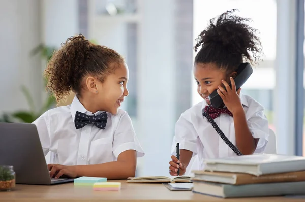 Did you get the deal. two adorable little girls dressed as businesspeople sitting in an office and using technology