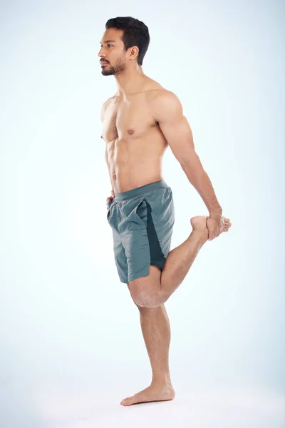 Spor Sağlık Stüdyoda Bacaklarını Esneten Bir Adam Mavi Bir Arka — Stok fotoğraf