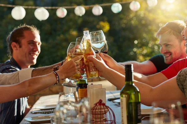 Life is better with friends in it. a group of happy young friends toasting with wine at a backyard dinner party