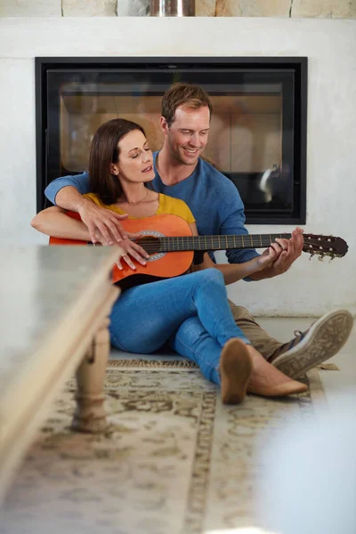 Enjoying a cosy and comfortable weekend together. a mature couple playing the guitar together at home