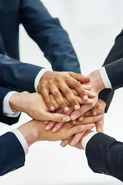 Success through unity. Closeup shot of a group of businesspeople standing in a huddle with their hands stacked together