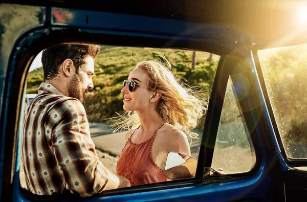 Traveling opens your heart. a young couple outside a pickup truck