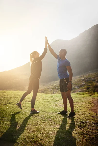 Awesome is never achieved in your comfort zone. a sporty couple high-fiving after a run