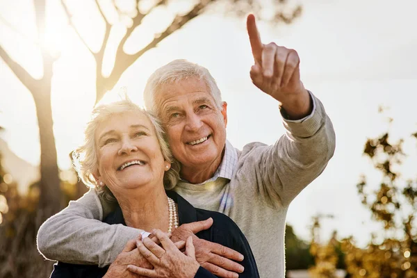 stock image All of that is for you my darling. a happy senior man pointing something out to his wife outdoors