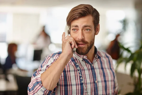 Success is always calling. a young businessman talking on a phone in an office