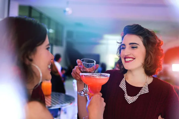 We should get together more often. two young women having cocktails at a social event