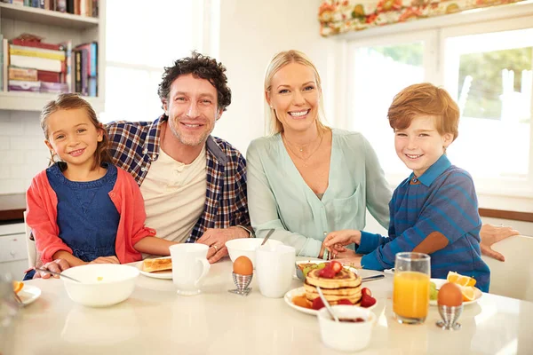 The best way to start the day is with family. Portrait of a family enjoying breakfast together at home