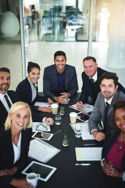 They will create a future for the business. Portrait of a group of businesspeople having a meeting together while looking into the camera in a boardroom at the office