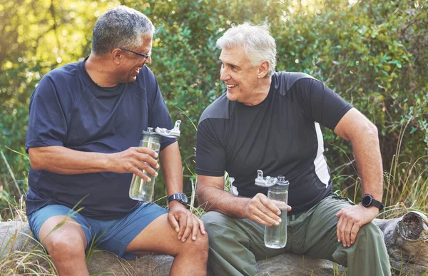 Fitness, friends and elderly men relax after run in park with water bottle, hydration and break after exercise. Body workout, senior runner and conversation after workout outdoor, energy and happy