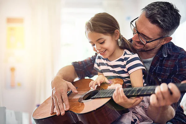 Youre a natural. a handsome mature man teaching his young daughter how to play the guitar