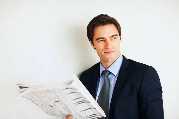 Young business man reading a newspaper with copyspace. Portrait of a young business man reading a newspaper with copyspace
