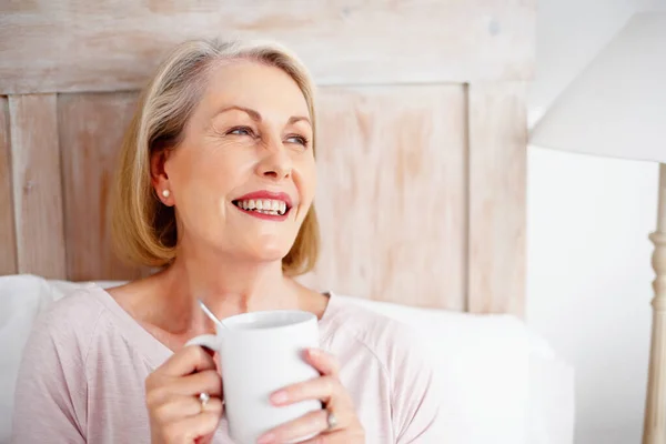Cheerful mature woman holding coffee mug. Closeup portrait of a cheerful mature woman holding coffee mug