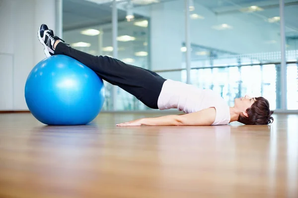 Exercise ball workout. Full length of woman using exercise ball during a workout session