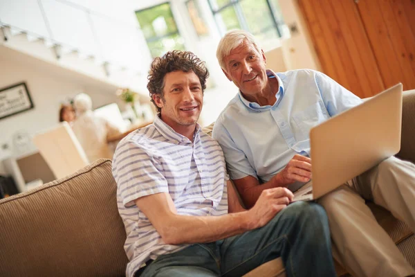 stock image Getting together for some father-son time. a man and his father sitting with a laptop indoors