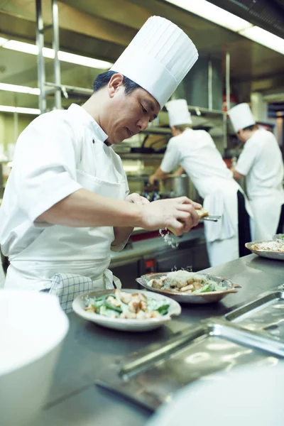 Plating up for service. chefs preparing a meal service in a professional kitchen