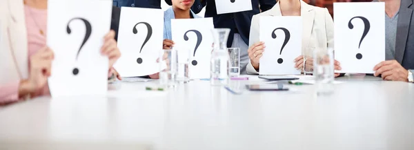 Have any questions. a group of businesspeople holding up cards with question marks on them
