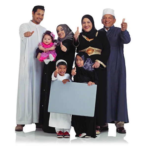 Theyre one enthusiastic family. Studio portrait of a happy muslim family holding up a blank sign isolated on white