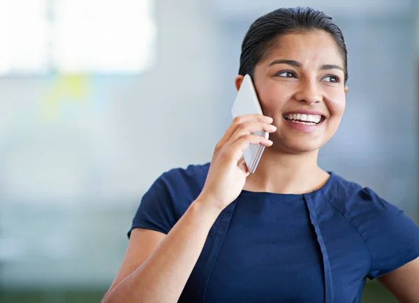 Its great to hear from you. an attractive young businesswoman using her cellphone in the office