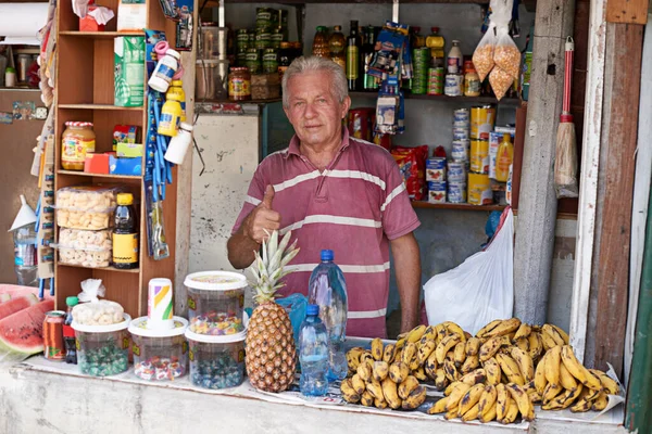 This is his livelihood. Portrait of a street vendor selling a variety of food at his stall