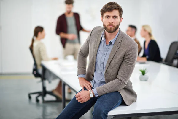 Focused on his career goals. Portrait of a young businessperson in a conference room with colleagues in the background