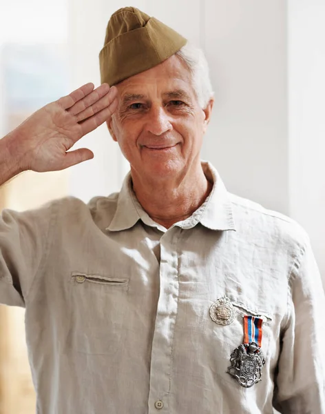 Proud veteran. A senior war veteran looking at the camera wearing his uniform