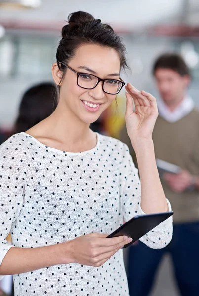 The intelligent move for creative professionals. Intelligent young woman smiling at the camera while holding a digital tablet
