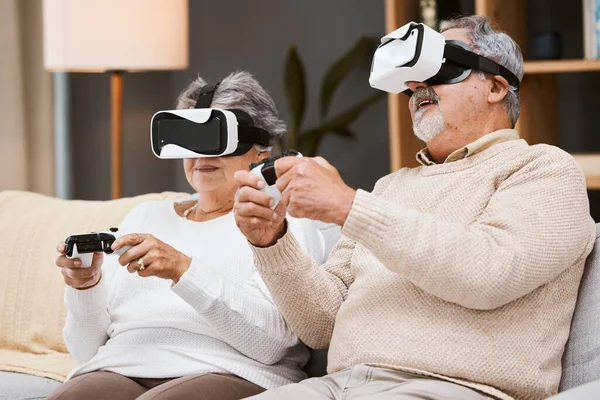 Virtual reality, gaming and senior couple on sofa in living room having fun. Vr gamer, metaverse and retired elderly man and woman playing futuristic, 3d and ai games with controller while relaxing