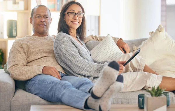 Mature couple, tablet and relax portrait on sofa together for love, support and romance bonding in living room at home. Man smile, happy woman, and romantic quality time on couch with tech device.