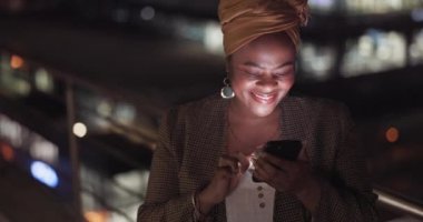 City, rooftop and black woman on a phone at night networking on social media or the internet. Technology, happiness and African lady browsing online with a cellphone on an outdoor balcony in a town