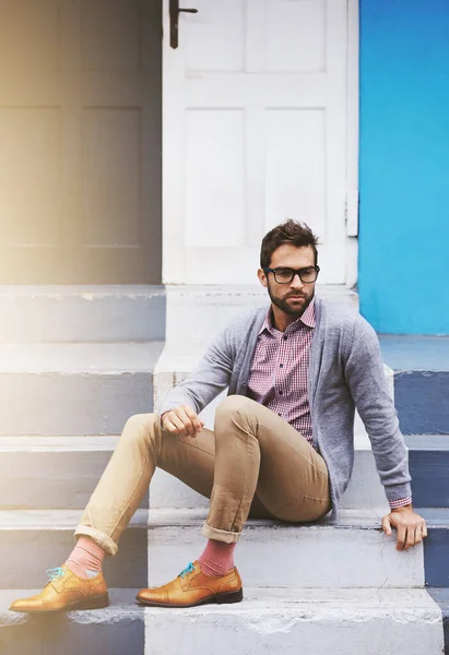 Hes a man of style. Full length shot of a stylish man sitting on a step outside