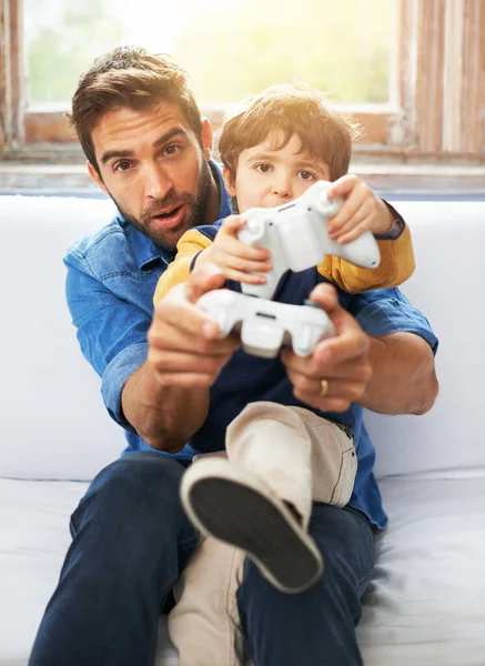 Getting into gaming. a father and his young son playing video games