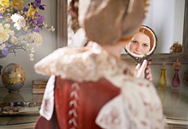 Beauty and elegance of the aristocratic. a noble lady looking at herself in a mirror clipart