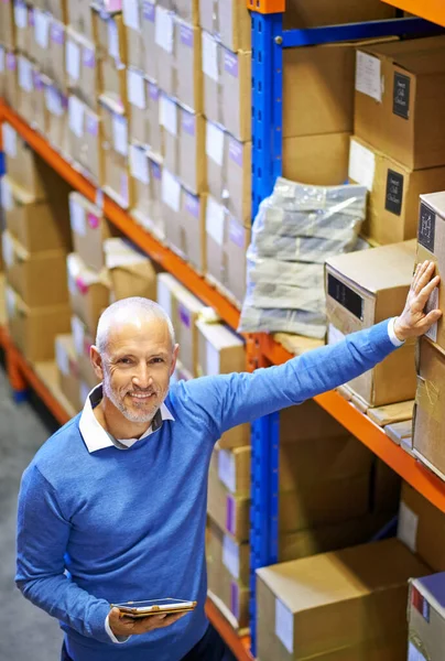 Your package is on its way. Portrait of a mature man working inside in a distribution warehouse