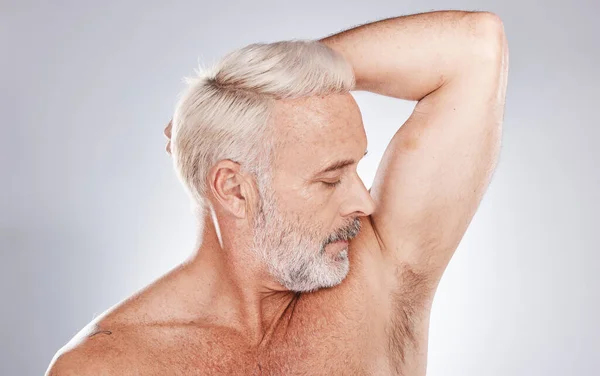Grooming, hygiene and man with fresh armpits, smelling clean and wellness after shower on a studio background. Healthcare, skincare and cosmetics senior model with underarm smell after cleaning body.